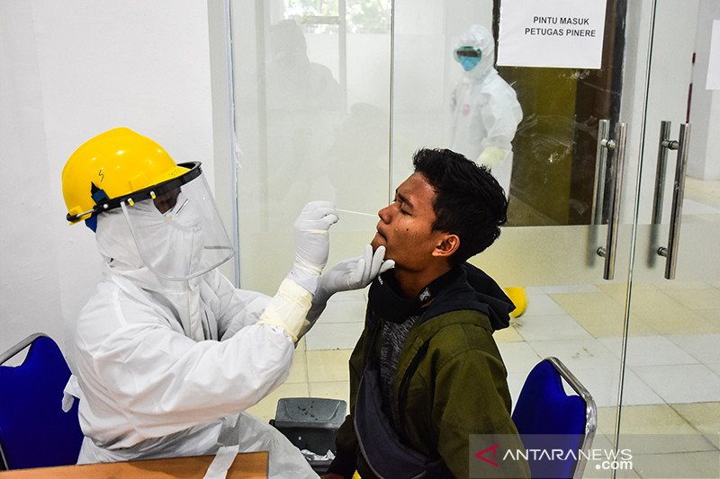 Tenaga kesehatan mengenakan alat pelindung diri mengambil spesimen usap warga yang membayar untuk tes PCR Poli Pinere RSUD Arifin Achmad, Kota Pekanbaru, Riau, Jumat (5/6). ANTARA FOTO/FB Anggoro