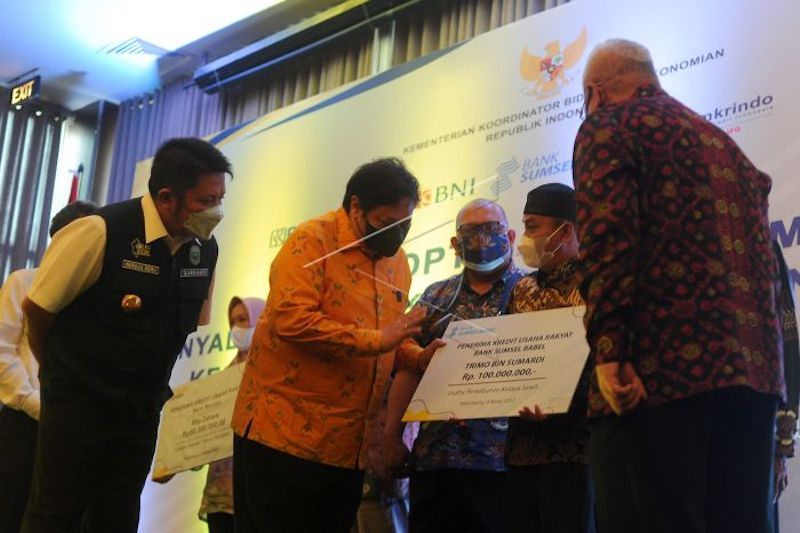 Menko Perekonomian Airlangga Hartarto (kedua kiri) dan Gubernur Sumatera Selatan Herman Deru (kiri) berbincang dengan salah satu debitur penerima saat menyerahkan penyaluran Kredit Usaha Rakyat (KUR) di Palembang, Sumatera Selatan, Jumat (4/3/2022). Pada kesempatan tersebut disalurkan KUR sebesar Rp4,23 miliar kepada 32 debitur di Sumatera Selatan. (ANTARA FOTO/Feny Selly)