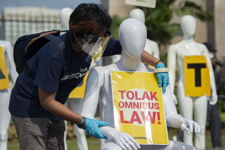 Aktivis Greenpeace memasang poster pada manekin saat aksi damai menolak pembahasan RUU Cipta Kerja di depan Kompleks Parlemen, Senayan, Jakarta, Senin (29/6/2020). ANTARA FOTO/Aditya Pradana Putra/wsj. (ANTARA FOTO/ADITYA PRADANA PUTRA)
