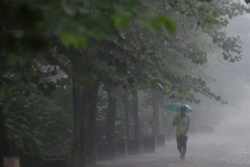 Warga menembus hujan di Jalan Merdeka Selatan, Jakarta