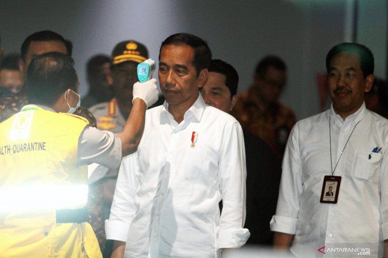 Presiden Joko Widodo (kedua kiri) disaksikan Kapolri Jendral Idham Aziz (kiri belakang) dan Presiden Direktur PT. Angkasa Pura II Muhammad Awaluddin (kanan) tengah diukur suhu tubuh oleh petugas KKP Soetta saat melakukan peninjauan kesiapan Bandara dalam menghadapi COVID-19 di Terminal 3 Bandara Soekarno Hatta, Tangerang, Banten, Jumat (13/3/2020). Dalam kunjungannya Presiden menegaskan bahwa pengecekan pergerakan manusia di bandara Soetta sudah sangat ketat. ANTARA FOTO/Muhammad Iqbal/hp.