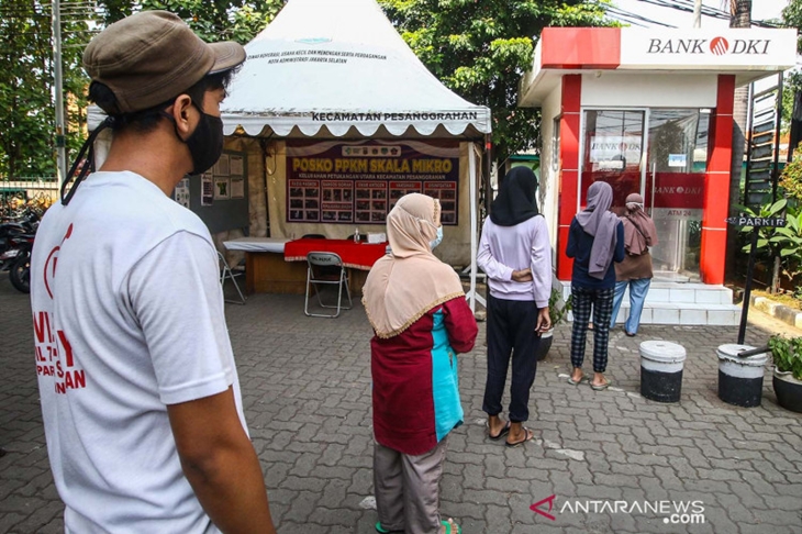 Warga antre untuk mengambil uang di ATM Bank DKI, Jakarta, Selasa (20/7/2021). Pemprov DKI menyiapkan anggaran Rp604 miliar untuk bantuan sosial tunai atau BST kepada 1 juta Kepala Keluarga (KK) penerima manfaat selama PPKM darurat. Nilai BST kali ini mencapai Rp600.000 per KK dari hasil rapelan penyaluran tahap 5 dan 6 yang sempat tertunda pada Mei-Juni 2021 lalu. ANTARA FOTO/Rivan Awal Lingga/aww.