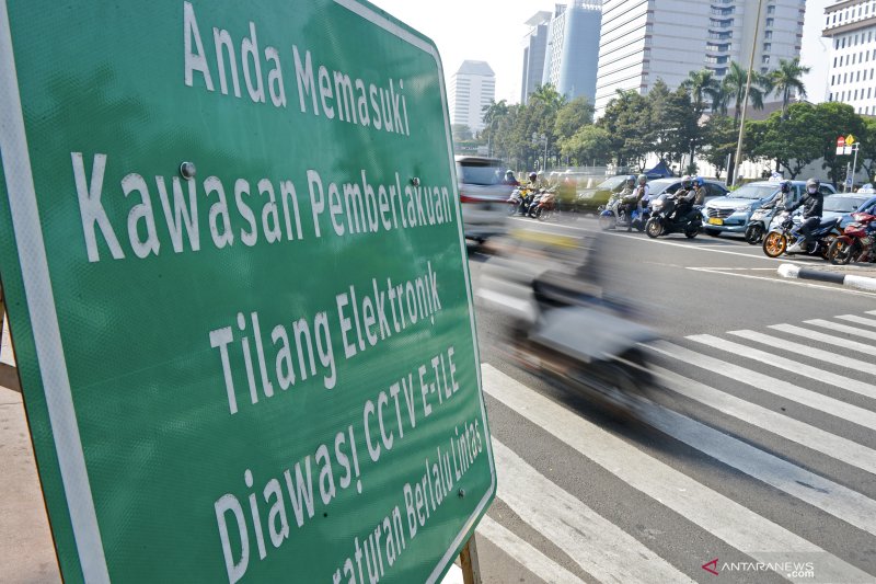 Pengendara melintas di dekat rambu tilang elektronik di kawasan Jalan Medan Merdeka Barat, Jakarta, Senin (1/7/2019). Direktorat Lalu Lintas Polda Metro Jaya menerapkan penilangan dengan sistem Electronic Traffic Law Enforcement (ETLE) dengan memasang 10 kamera baru dengan fitur tambahan yang dapat mendeteksi pemakaian sabuk pengaman, penggunaan telepon genggam oleh pengemudi, nomor pelat ganjil genap dan batas kecepatan pengemudi. ANTARA FOTO/Nova Wahyudi/foc