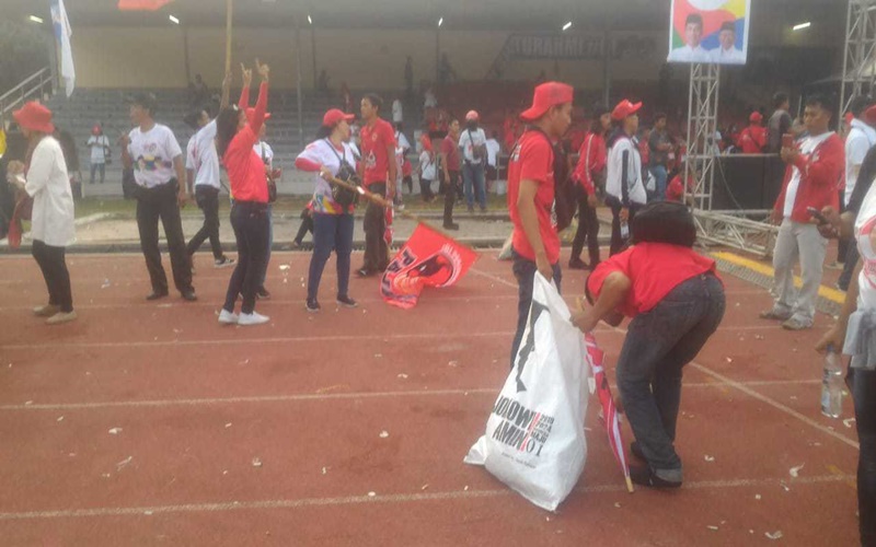Panitia dan relawan kampanye Jokowi membersihkan sampah di Stadion Sriwedari