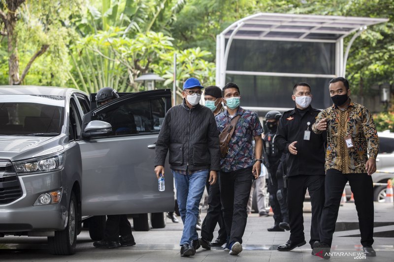 Gubernur Sulawesi Selatan Nurdin Abdullah (kiri) dikawal petugas setibanya di gedung KPK, Jakarta, Sabtu (27/2/2021). KPK mengamankan NurdinÊAbdullahÊmelalui Operasi Tangkap Tangan (OTT) bersama lima orang lainnya dengan barang bukti sebuah koper berisi uang. ANTARA FOTO/Dhemas Reviyanto/aww.