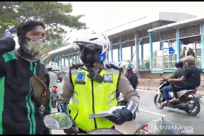 Pengemudi ojek daring ditilang petugas polisi lalu lintas saat melanggar lalu lintas di Jalan Sumur Bor Cengkareng, Jakarta Barat, Jumat (24/7/2020). (ANTARA/Devi Nindy)