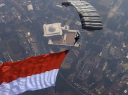 Spektakuler! 17 Penerjun Kopassus Kibarkan Merah Putih di Langit Monas