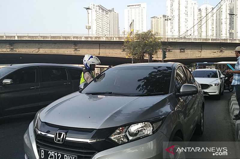 Polisi menilang kendaraan mobil berplat genap yang melintas Jalan Tomang Raya Jakarta Barat, Senin (9/9/2019). (ANTARA News/DEVI NINDY)