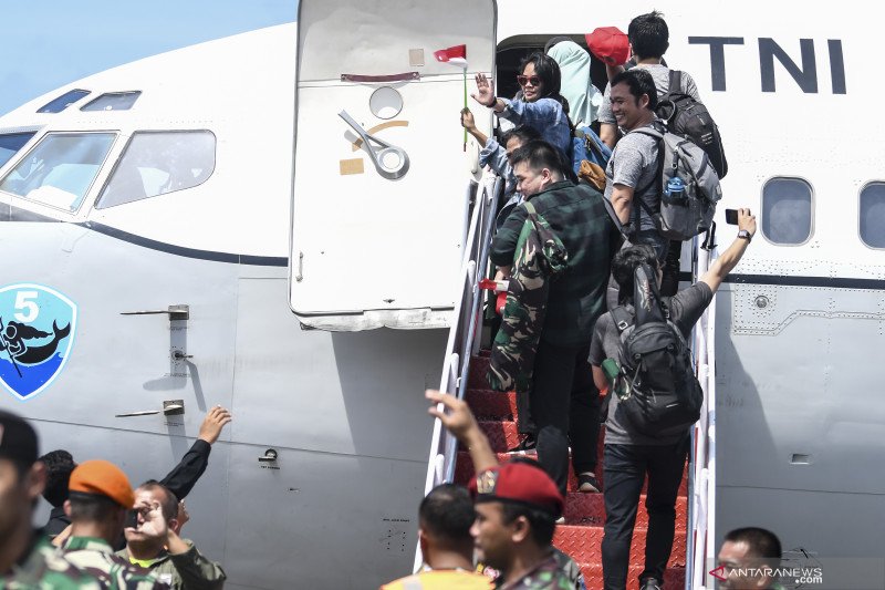 Warga Negara Indonesia (WNI) yang dievakuasi dari Wuhan, Provinsi Hubei, China menaiki tangga pesawat udara usai menjalani masa observasi di Hanggar Pangkalan Udara TNI AU Raden Sadjad, Ranai, Natuna, Kepulauan Riau, Sabtu (15/2/2020). ANTARA FOTO/Muhammad Adimaja/wsj. (ANTARA FOTO/MUHAMMAD ADIMAJA).