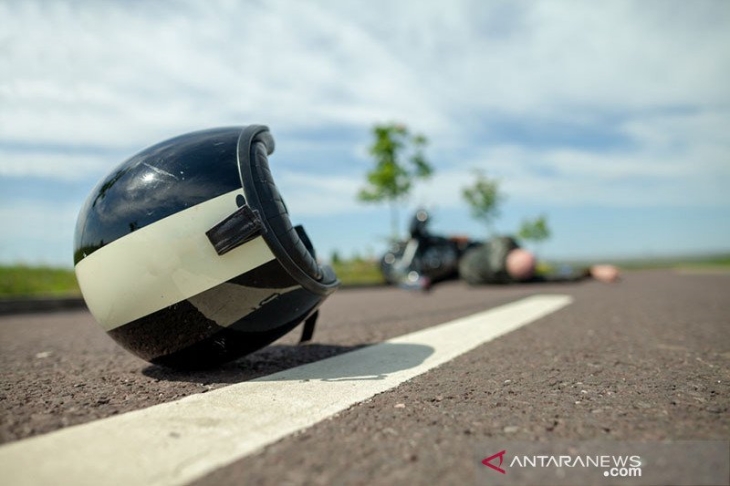 Helm pemotor tergeletak di jalan dekat kecelakaan sepeda motor. (Foto: ANTARA/Shutterstock/pri)	