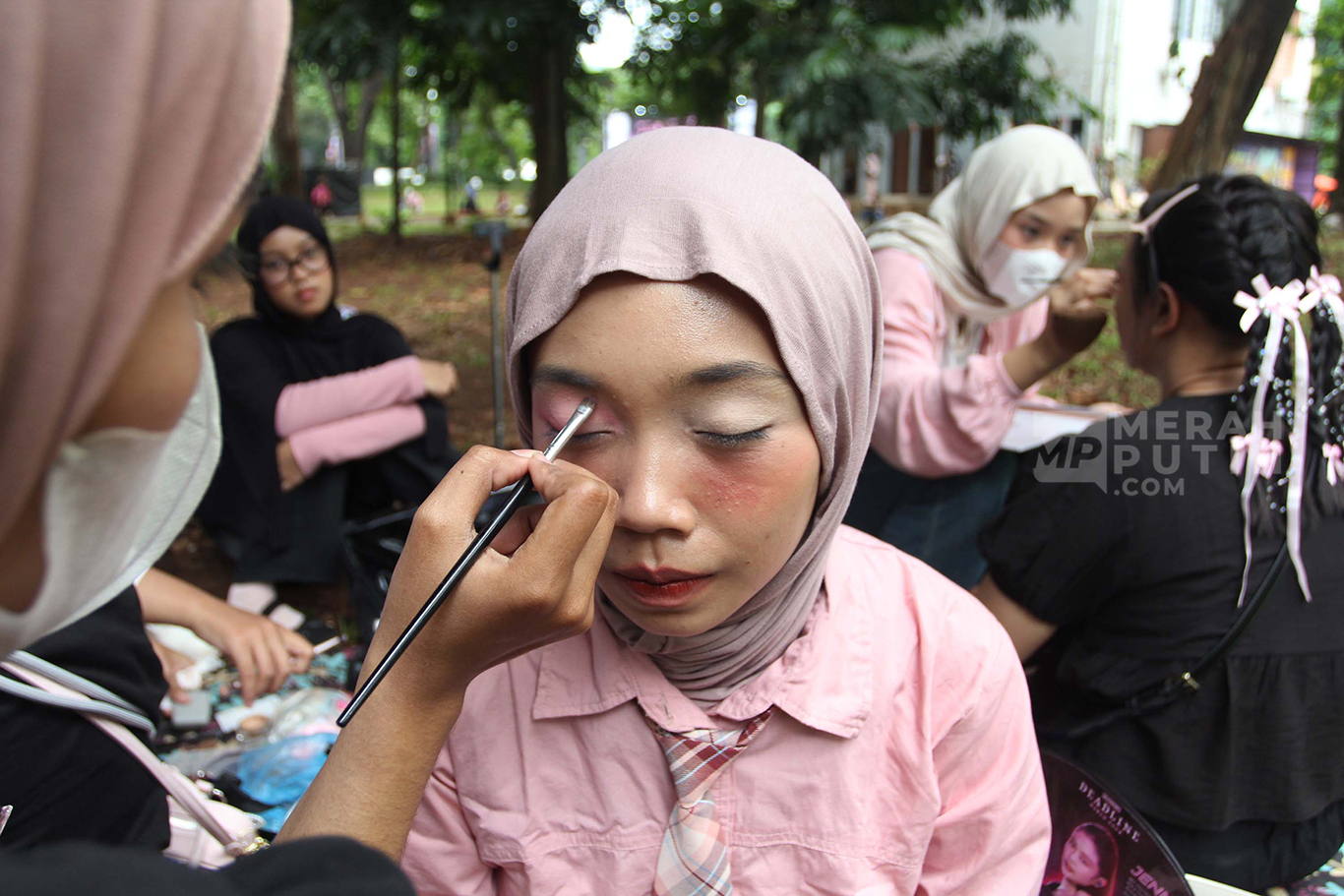 Suasana mahasiswi melayani jasa rias wajah atau make-up untuk penggemar Girl Band asal Korea Selatan Black Pink sebelum konser di Kawasan Stadion Utama Gelora Bung Karno (SUGBK), Senayan, Jakarta, Sabtu (01/11/2025).