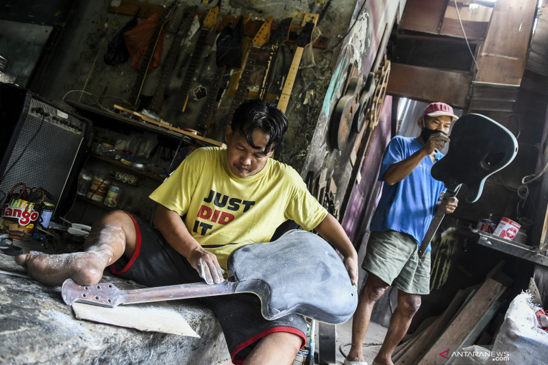 Pekerja menyelesaikan pembuatan gitar di Service Guitar Pak Manto, Pejaten Timur, Pasar Minggu, Jakarta, Selasa (3/8/2021). . ANTARA FOTO/Galih Pradipta/rwa.