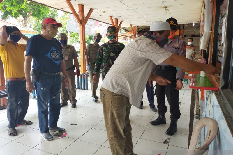 Persiapan menghadapi normal baru, agen tiket perusahaan otobus menerapkan protokol kesehatan COVID-19 dengan menyanitasi tangan di Terminal Kalideres, Jakarta, Sabtu (30/5/2020). (ANTARA/HO-Polres Metro Jakarta Barat)