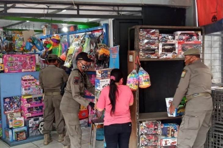 Petugas Satpol PP Jatinegara menutup toko mainan di Pasar Gembrong, Jakarta Timur, Selasa (2/6/2020), sebab masih beroperasi selama masa pandemi COVID-19. (ANTARA/HO-Satpol PP Jatinegara)
