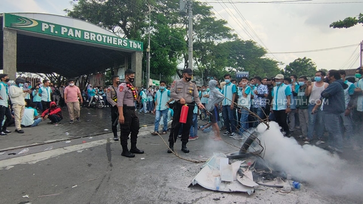 Polisi memadamkan ban yang dibakar dalam demo buruh PT Pan Brothers Tbk di Kabupaten Boyolali, Jawa Tengah, Rabu (5/5). (Foto: MP/Ismail)