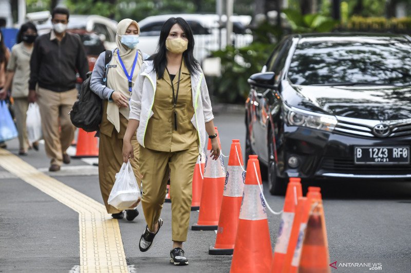 Sejumlah Pegawai Negeri Sipil (PNS) lingkup Pemprov DKI Jakarta berjalan memasuki ruang dinasnya saat hari pertama masuk kerja usai libur lebaran di Balai Kota, Jakarta, Senin (17/5/2021). ANTARA FOTO/M Risyal Hidayat
