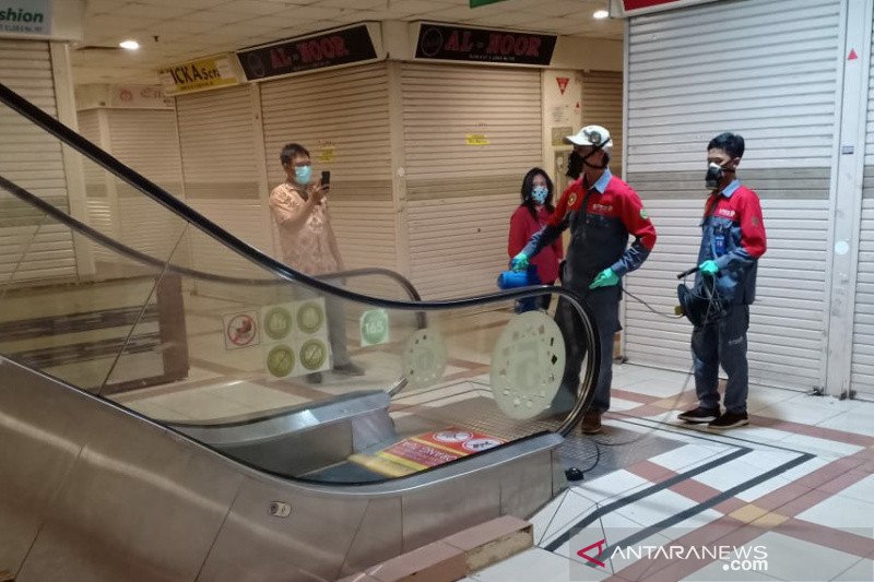 Petugas melakukan penyemprotan disinfektan di Pasar Tanah Abang Blok B yang ditutup untuk menekan penyebaran virus corona (COVID-19) Jumat (20/3/3020). (ANTARA/Livia Kristianti)