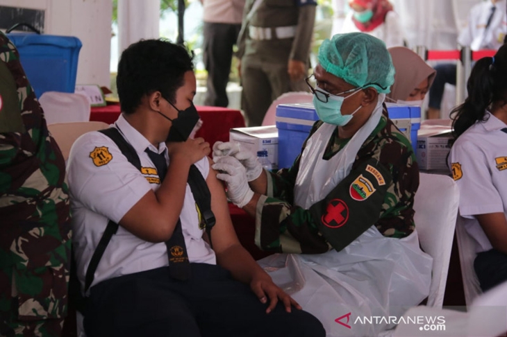 Seorang pelajar SMP sedang menjalani vaksinasi massal di SMP Negeri 11 Medan, Rabu (14/7/2021). (ANTARA/HO)