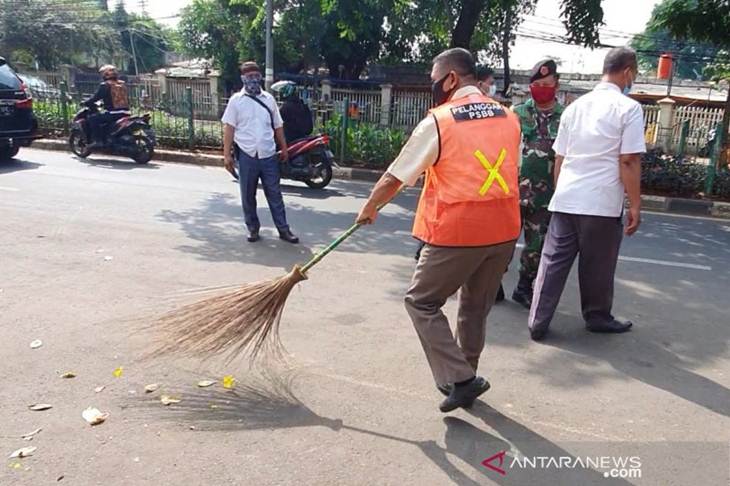 Pelanggar PSBB yang melakukan sanksi sosial membersihkan jalan karena terjaring dalam penertiban yang dilakukan oleh Pemerintah Kota Jakarta Pusat di Pasar Senen, Rabu (10/6/2020). (ANTARA/Livia Kristianti)