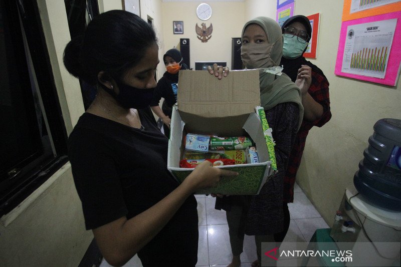 Warga memperlihatkan isi bantuan sembako pemerintah sebagai bantuan pangan akibat wabah COVID-19 di kawasan RW 03 Kebon Kacang, Jakarta, Minggu (12/4/2020). Bantuan sembako Pemprov DKI Jakarta tersebut guna meringankan beban perekonomian warga setempat yang terdampak COVID-19 di wilayah DKI Jakarta selama masa Pembatasan Sosial Berskala Besar (PSBB). ANTARA FOTO/Reno Esnir/aww