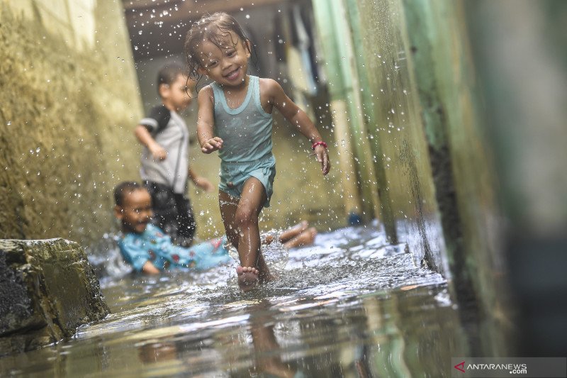 Sejumlah bocah bermain air saat banjir merendam kawasan Kedoya Utara, Jakarta, Minggu (21/2).  ANTARA FOTO/Muhammad Adimaja
