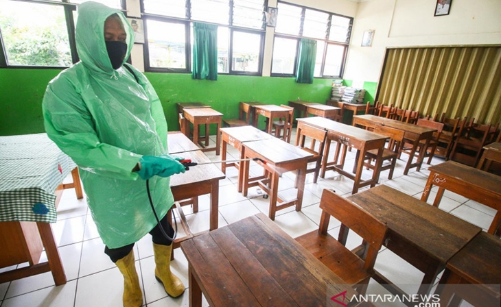 Petugas menyemprotkan cairan disinfektan di dalam kelas SDN Kebayoran Lama Selatan 17 Pagi, Jakarta, Rabu (25/8/2021). ANTARA FOTO/Rivan Awal Lingga/aww.