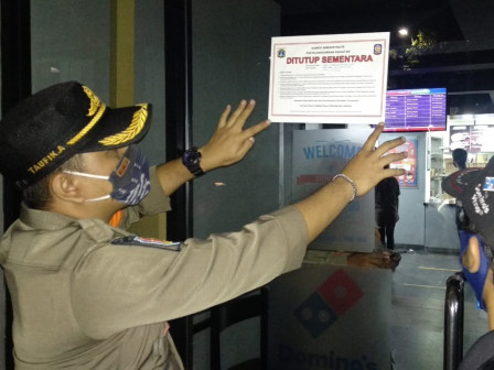Satpol PP Jakarta Selatan, menutup sementara satu gerai usaha kuliner di Jalan Wijaya I, Kelurahan Petogogan, Kebayoran Baru, Kamis (31/12) malam. Foto: 