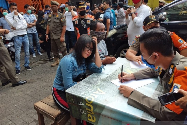 Aparat Satpol PP Jakarta Barat mendata para pengunjung Diskotek Top One yang melanggar aturan PSBB transisi fase 1 di Jakarta, Jumat (3/7/2020). (ANTARA/Devi Nindy)