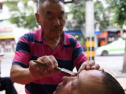 Tukang Cukur Bersihkan Mata dengan Silet