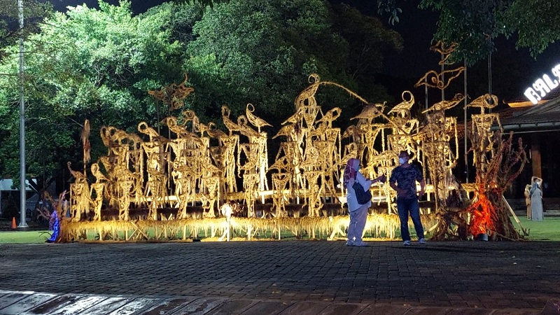 Warga berfoto di dekat seni instalasi wayang jerami di Plaza Balai Kota Solo, Jawa Tengah, Rabu (8/12) malam. (MP/Ismail)