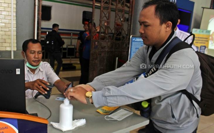 Calon penumpang kereta menggunakan hand sanitizer di chek-in boarding. (Foto: MP/Mauritz)