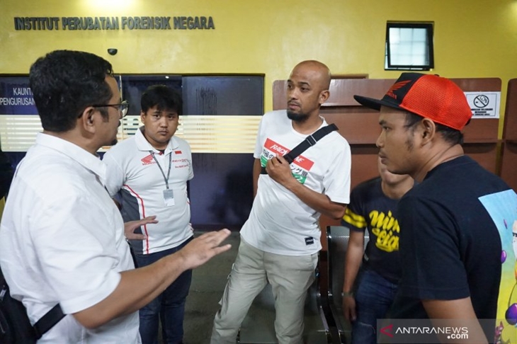 Kepala Satgas Perlindungan WNI KBRI Kuala Lumpur Yusron B Ambary (kiri) berbincang-bincang dengan anggota Tim Asia Talent Cup (ATC) Indonesia Charlie (Kedua kiri) dan Dandy (kedua kanan) saat mengurus jenazah pebalap Afridza Syach Munandar di Institut Perubatan Forensik Negara Hospital Kuala Lumpur, Malaysia, Sabtu (11/2/2019). Almarhum Afridza Syach Munandar meninggal dunia dalam balap motor Asia Talent Cup di Sepang International Circuit pada hari ini. (ANTARA FOTO/Agus Setiawan)