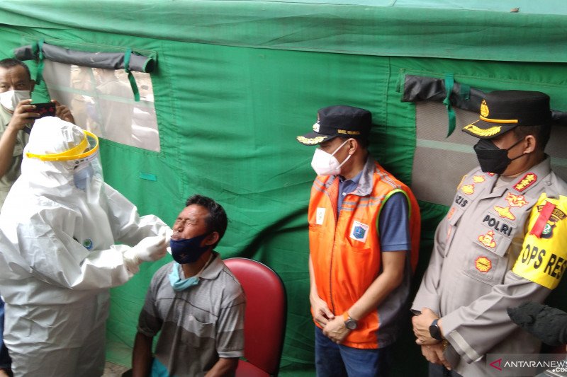 Petugas medis melakukan tes usap antigen kepada seorang warga setelah kembali ke Jakarta usai mudik serangkaian Idul Fitri 1442 Hijriah di Duren Tiga, Pancoran, Jakarta Selatan, Minggu (16/5/2021). (ANTARA/Dewa Ketut Sudiarta Wiguna)
