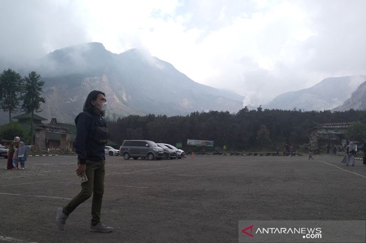 Pengunjung menggunakan masker berjalan di area parkir Taman Wisata Alam Gunung Papandayan di Kabupaten Garut, Jawa Barat, Minggu (3/10/2021). ANTARA/Feri Purnama