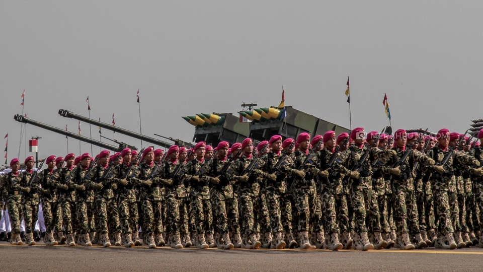 Pasukan Korps Marinir TNI Angkatan Laut mengikuti parade dan defile pada perayaan HUT ke-74 Tentara Nasional Indonesia (TNI) di Taxi Way, Lanud Halim Perdana Kusuma, Jakarta, Sabtu, (5/10/2019). Pada perayaan tahun 2019, TNI mengusung tema "TNI Profesional Kebanggan Rakyat". Upacara tersebut diisi oleh peragaan keterampilan prajurit, bela diri militer, tari perang garuda, terjun payung, demo udara, jupiter aerobatic, hingga parade dan defile berkekuatan 6.806 personel. Merahputih.com / Rizki Fitrianto