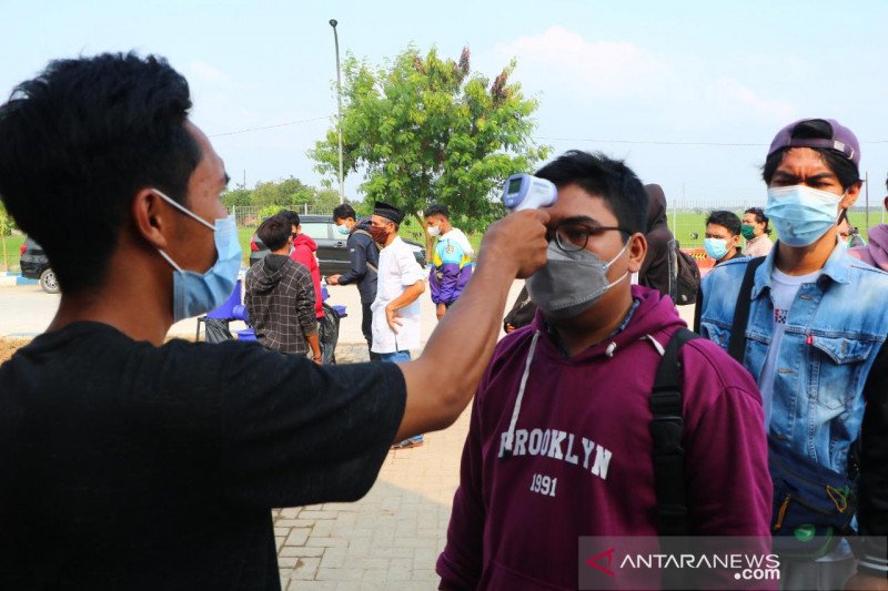 Petugas kesehatan melakukan tes suhu tubuh kepada para pendatang di Bakaheuni untuk mewaspadai penularan COVID-19 melalui aktivitas mudik Lebaran 2021, Selasa (18/5/2021). (ANTARA/HO-Kemenko PMK).