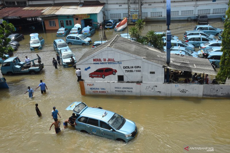 Pekerja dibantu warga mendorong taksi yang terendam banjir di Pool Taksi Bluebird Rawa Buaya, Jakarta Barat, Kamis (2/1/2020). ANTARA FOTO/Indrianto Eko Suwarso/foc.