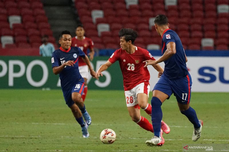 Pesepak bola Timnas Indonesia Alfreanda Dewangga (tengah) berusaha masuk ke pertahanan lawan dengan dibayangi pesepak bola Timnas Singapura Hami Syahin (kiri) dalam pertandingan Semi Final Leg 2 Piala AFF 2020 di National Stadium, Singapura, Sabtu (25/12/2021). Indonesia melaju ke babak final usai melibas Singapura 4-2 (5-3). ANTARA FOTO/Humas PSSI