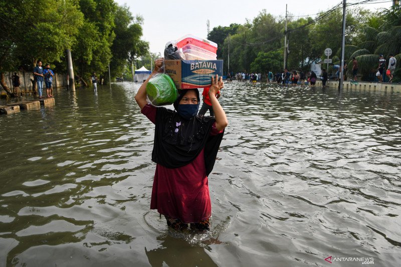 Warga melintasi banjir air rob di kawasan Muara Baru, Penjaringan, Jakarta Utara, Jumat (5/6/2020). ANTARA FOTO/M Risyal Hidayat/wsj. (ANTARA FOTO/M RISYAL HIDAYAT)