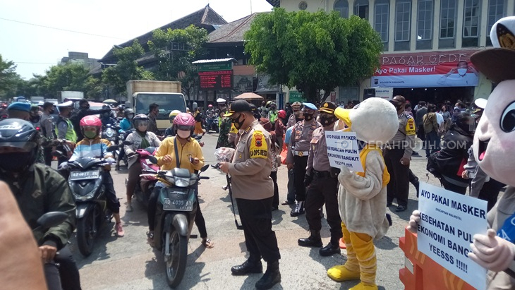 Anggota Polresta Surakarta sosialisasi penerapan protokol kesehatan di depan Pasar Gede Solo, Jawa Tengah. (MP/Ismail)