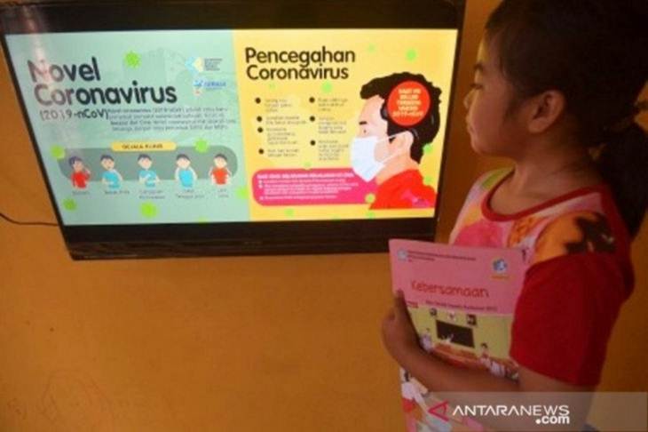 Seorang pelajar melihat informasi seputar virus Corona (COVID-19) dan cara pencegahannya di rumahnya di Palu, Sulawesi Tengah, Sabtu (28/3/2020). ANTARA FOTO/Mohamad Hamzah/hp.