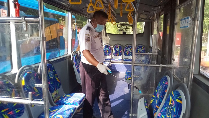 Petugas Dishub Solo melakukan penyemprotan dalam angkutan umum