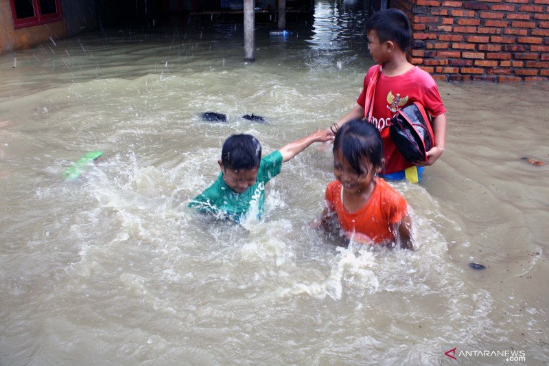 Anak-anak bermaindi genangan air saat banjir melanda Desa Karangligar, Kecamatan Telukjambe Barat, Karawang, Jawa Barat. (ANTARA FOTO/M.Ali Khumaini)