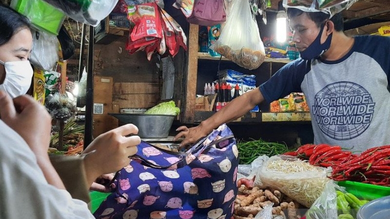 Pedagang sayur melayani pembeli yang berbelanja menggunakan kantong belanja ramah lingkungan di Pasar Tebet Barat, Jakarta Selatan, Senin (20/7/2020). (ANTARA/Laily Rahmawaty)