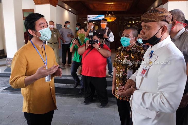 Ketua Pelaksana Gugus Tugas Percepatan Penanganan COVID-19 Solo Ahyani (kanan) menerima bantuan APD dari Gibran Rakabuming Raka (kiri). (MP/Ismail)