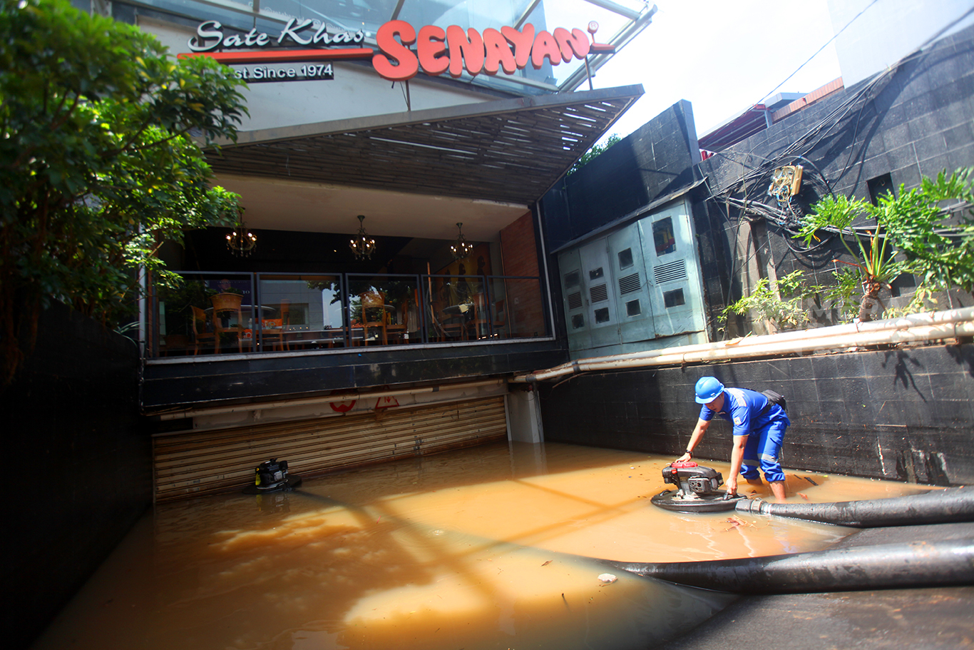 Petugas dari Dinas Sumber Daya Air (SDA) Jakarta Selatan mengoperasikan mesin pompa untuk menyedot air banjir yang menggenangi basement bangunan di Jalan Raya Kemang, Jakarta Selatan, jum'at (31/10/2025).