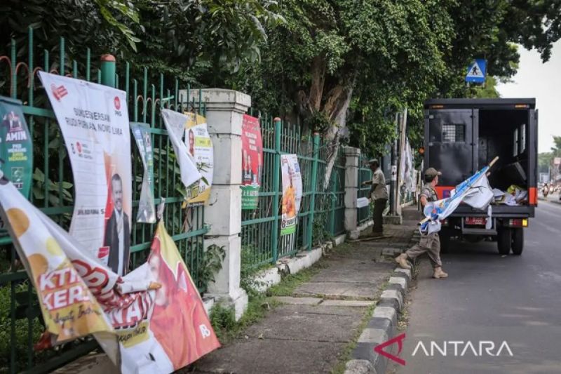 Petugas memasukkan alat peraga kampanye (APK) ke dalam mobil saat penertiban di Cijantung, Jakarta, Minggu (11/2)