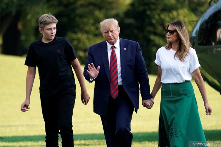 Presiden Amerika Serikat Donald Trump melambaikan tangan saat berjalan bersama Ibu Negara Melania Trump dan putra mereka Barron di Halaman Selatan Gedung Putih setelah kembali ke Washington dari Bedminster, New Jersey, Amerika Serikat, Minggu (18/8/2019). ANTARA FOTO/REUTERS/Yuri Gripas/djo/ama