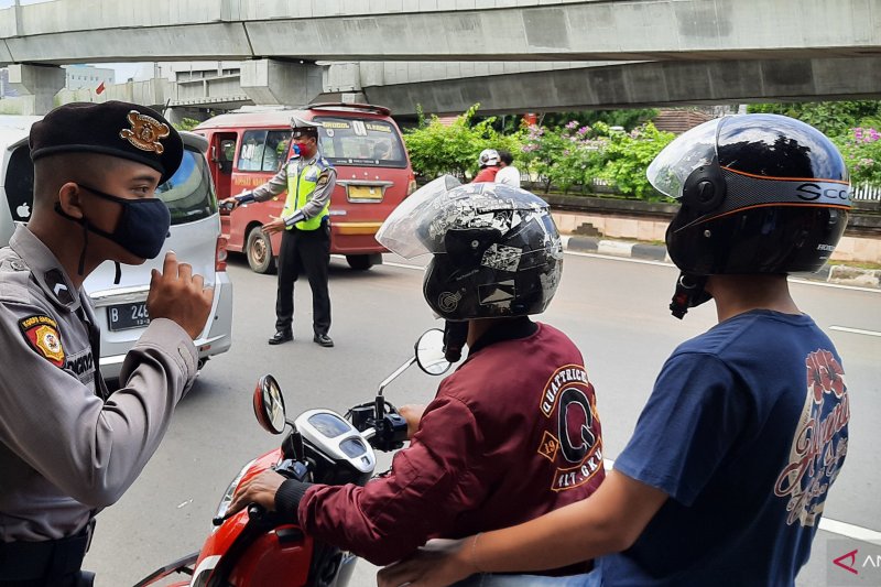 Petugas Polres Metro Jakarta Selatan menegur pengedara sepeda motor yang kedapatan tidak menggunakan masker saat melintas di 'check point' Pembatasan Sosial Berskala Besar (PSBB) Pasar Jumat, Kebayoran Lama, Jakarta Selatan, Sabtu (11/4/2020) (ANTARA/Laily Rahmawaty)