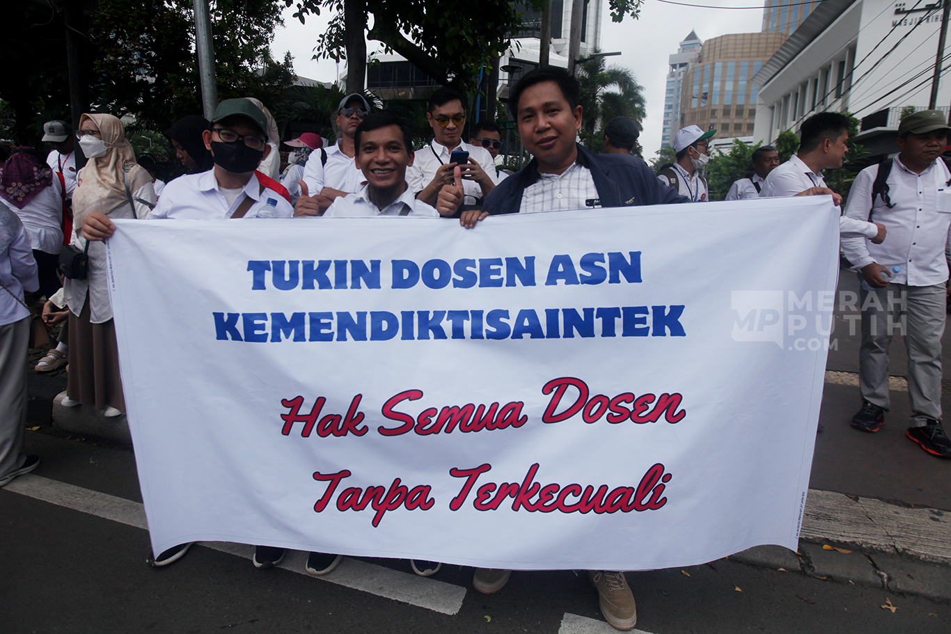 Dosen yang tergabung dalam Aliansi Dosen ASN Kemdiktisaintek Seluruh Indonesia (ADAKSI) membawa spanduk saat menggelar aksi di kawasan Patung Kuda, Jakarta, Senin (3/2/2025).